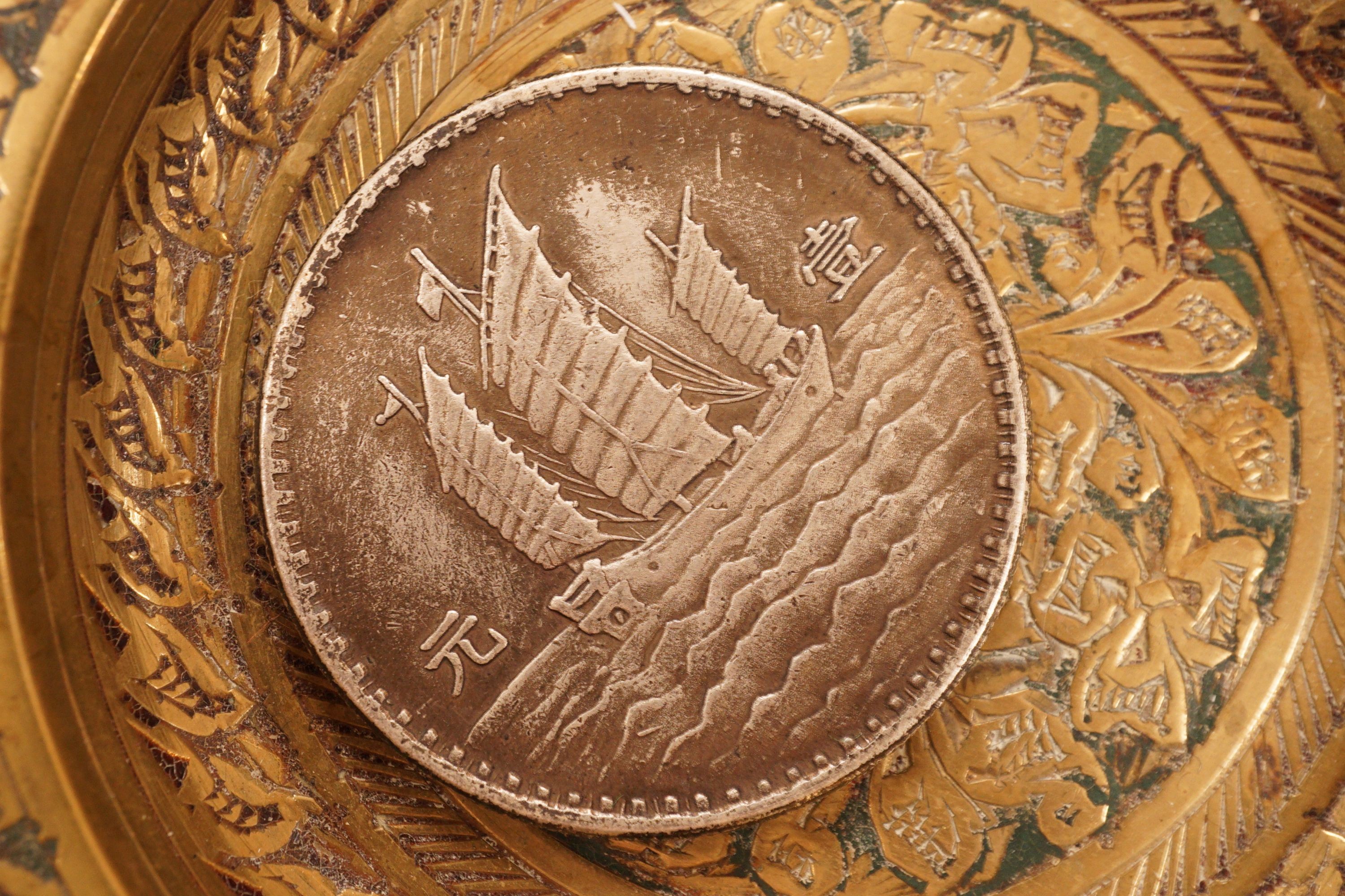 A brass tray, various coins and a rattle dish, 11.5cm diameter